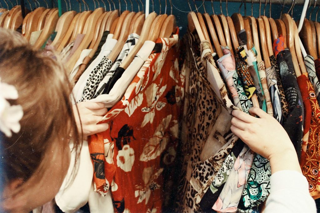 femme qui fait du shopping et regarde des vêtements sur des cintres