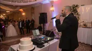 Un DJ au micro, guidant les invités pendant le toast ou l’arrivée du gâteau.
